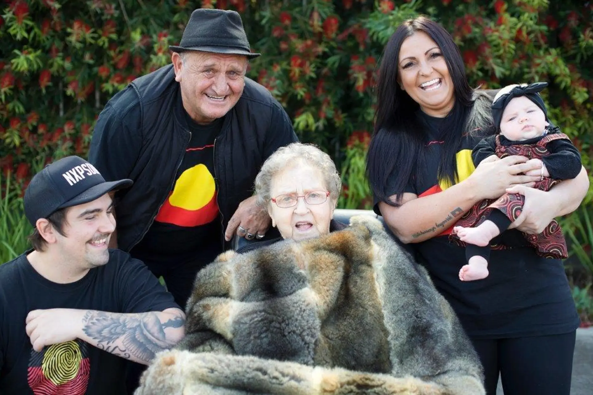 Joyce Eccles, Wadawurrung Elder, seated in a possum skin cloak surrounded by five generations of her Wadawurrung family