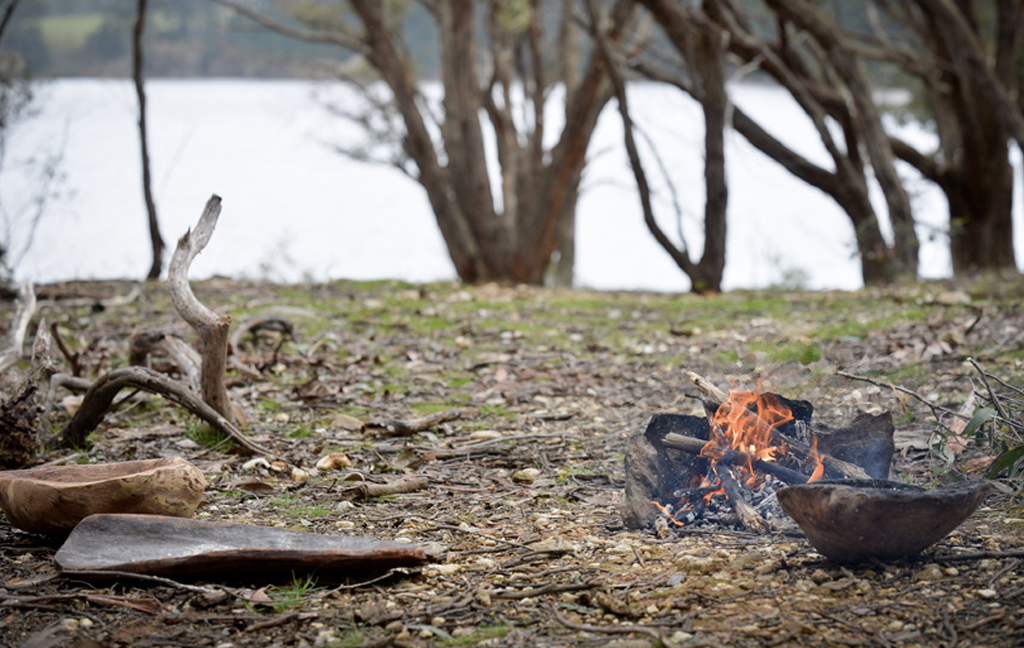 Small fire and coolamons beside water on Wadawurrung Country